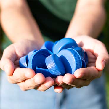 person holding blue bottle caps